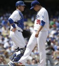 Los Angeles Dodgers starting pitcher Hyun-Jin Ryu, right, of South Korea, talks with catcher A.J. Ellis during the second inning of a baseball game against the San Francisco Giants on Friday, April 4, 2014, in Los Angeles. (AP Photo/Jae C. Hong)