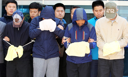 Crewmembers of the sunken ferry Sewol, including the chief engineer, two chief mates and a second mate, stand in front of reporters after being questioned during a judge’s review of prosecutors’ request for arrest warrants for abandoning passengers, at the Mokpo branch of the Gwangju District Court. (Yonhap)  
