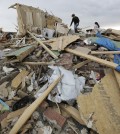 Austin Hargrove, left, and Haley Hracke, right, help recover personal items from a friends home that was destroyed by Sunday's tornado, Tuesday, April 29, 2014, in Vilonia, Ark.  A dangerous storm system that spawned a chain of deadly tornadoes over three days flattened homes and businesses, forced frightened residents in more than half a dozen states to take cover and left tens of thousands in the dark Tuesday morning. (AP Photo/Eric Gay)