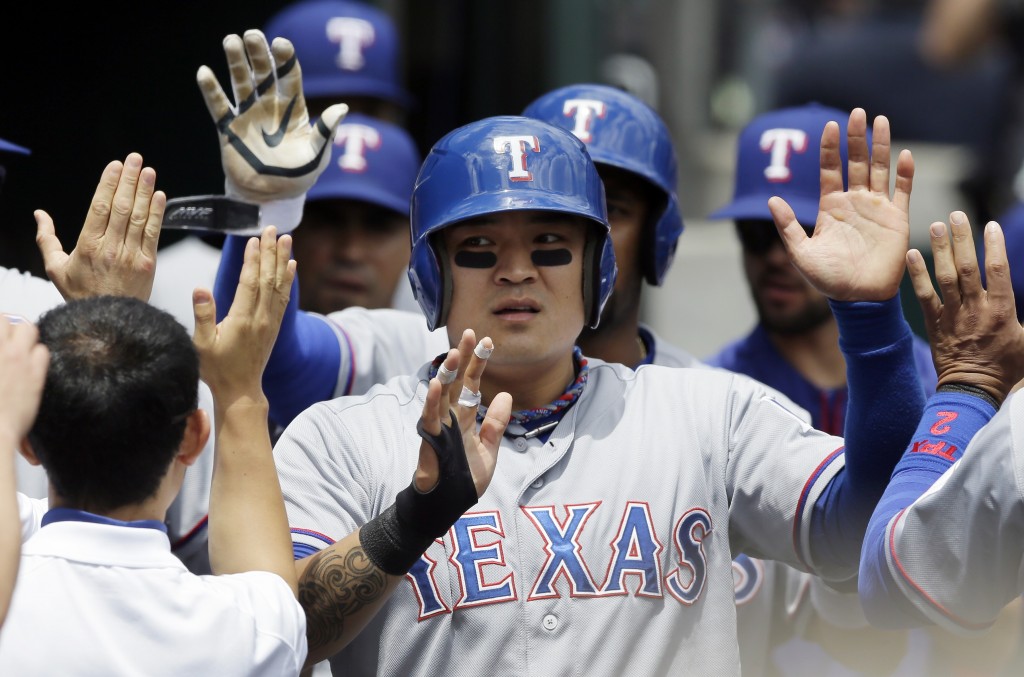 Texas Rangers' Shin-Soo Choo is greeted in the dugout after scoring on a double by Adrian Beltre during the third inning of a baseball game against the Detroit Tigers in Detroit, Thursday, May 22, 2014. Choo homered, Chris Gimenez had four hits and the Rangers rolled to a 9-2 victory over the Tigers. (AP Photo/Carlos Osorio)