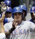 Texas Rangers' Shin-Soo Choo is greeted in the dugout after scoring on a double by Adrian Beltre during the third inning of a baseball game against the Detroit Tigers in Detroit, Thursday, May 22, 2014. Choo homered, Chris Gimenez had four hits and the Rangers rolled to a 9-2 victory over the Tigers. (AP Photo/Carlos Osorio)