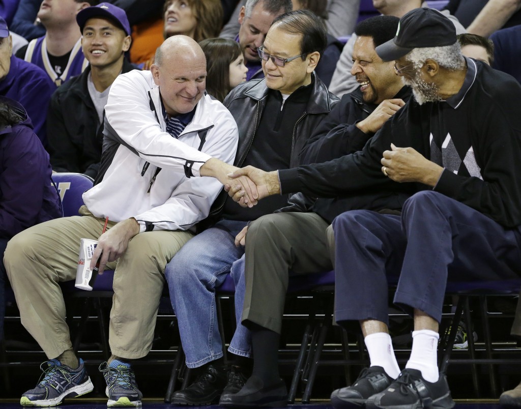 FILE - In this Jan. 25, 2014, photo, then-Microsoft CEO Steve Ballmer, left, shakes hands with former NBA players Bill Russell, right, and "Downtown" Freddie Brown as Omar Lee looks on during an NCAA college basketball game between Washington and Oregon State in Seattle. An individual with knowledge of negotiations to sell the Los Angeles Clippers said Shelly Sterling has reached an agreement to sell the team to Ballmer for $2 billion. The individual, who wasn뭪 authorized to speak publicly, told The Associated Press on Thursday, May 29, 2014, that Ballmer and the Sterling Family Trust now have a binding agreement. The deal now must be presented to the NBA. (AP Photo/Elaine Thompson, File)