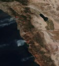 This May 14, 2014 image provided by NASA shows numerous large wildfires burning across sections of northern Baja and southern California, producing plumes of moderate to dense smoke and combining with blowing dust and sand moving west off the coast and well into the Pacific Ocean. Nine fires in all were burning an area of more than 14 square miles amid a heat wave and dry conditions, said San Diego County officials, who warned also of poor air quality with black and gray smoke wafting over the region. (AP Photo/NASA)