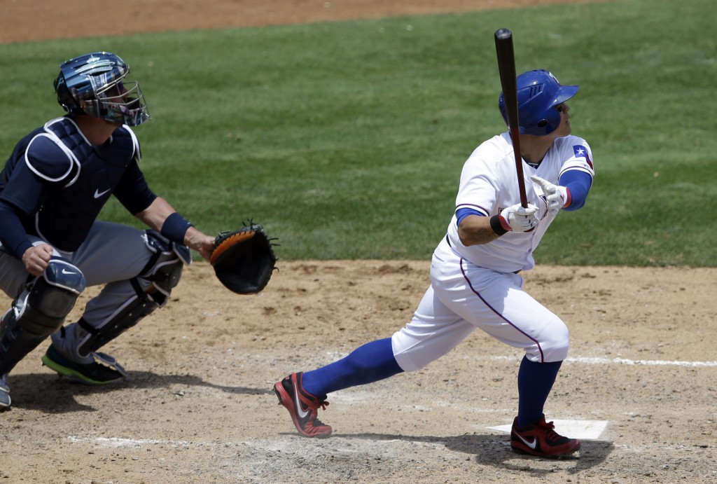 Texas Rangers' Shin-Soo Choo of South Korea and Seattle Mariners catcher John Buck, left, watch the flight of Choo's solo home run off a pitch from Mariners starter Chris Young in the fifth inning of a baseball game, Wednesday, May 21, 2014, in Arlington, Texas. (AP Photo/Tony Gutierrez)