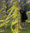 A girl ties yellow ribbons with messages for missing passengers aboard the sunken ferry boat Sewol in the water off the southern coast, in Seoul, South Korea, Friday, May 2, 2014. More than 300 people are dead or missing in the disaster that has caused widespread grief, anger and shame. (AP Photo/Lee Jin-man)