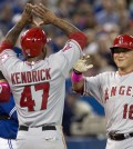 Los Angeles Angels' Hank Conger, right, is congratulated by teammates Efren Navarro, left, and Howie Kendrick after hitting a three-run home run off Toronto Blue Jays pitcher Marcus Stroman during sixth-inning baseball game action in Toronto, Sunday, May 11, 2014. (AP Photo/The Canadian Press, Frank Gunn)
