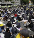 Family members of the victims of the sunken ferry Sewol and citizens sit on the street near the presidential Blue House in Seoul, South Korea, Friday, May 9, 2014. Family members marched to the presidential Blue House in Seoul early Friday calling for a meeting with President Park Geun-hye but ended up sitting on streets near the presidential palace after police officers blocked them. Park's office said a senior presidential official plans to meet them later Friday. (AP Photo/Lee Jin-man)