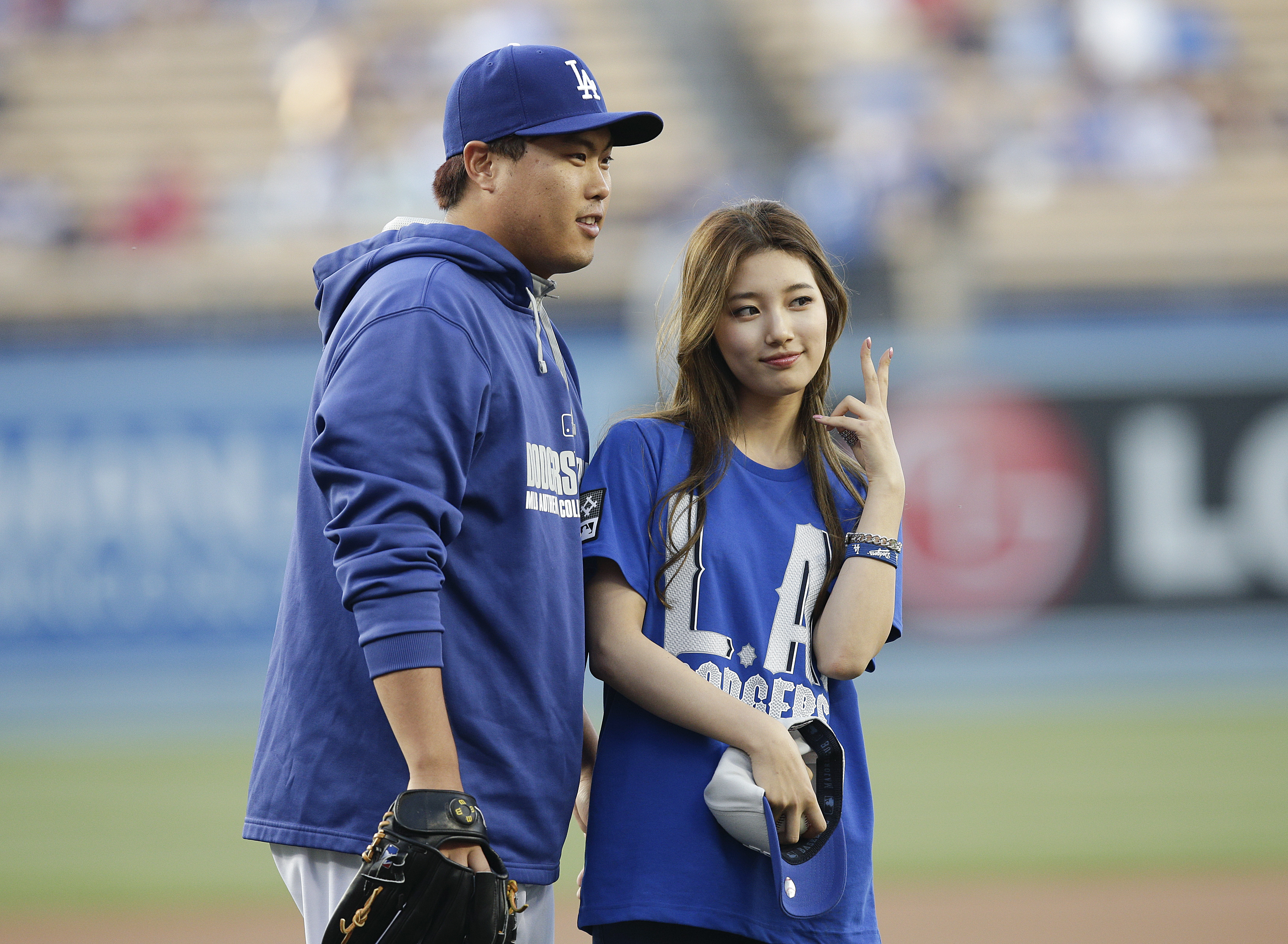 Los Angeles Dodgers starting pitcher Hyun-Jin Ryu, left, of South Korea, poses with South Korean singer Suzy after she threw the ceremonial first pitch before the team's baseball game against the Cincinnati Reds on Wednesday, May 28, 2014, in Los Angeles. (AP Photo/Jae C. Hong)