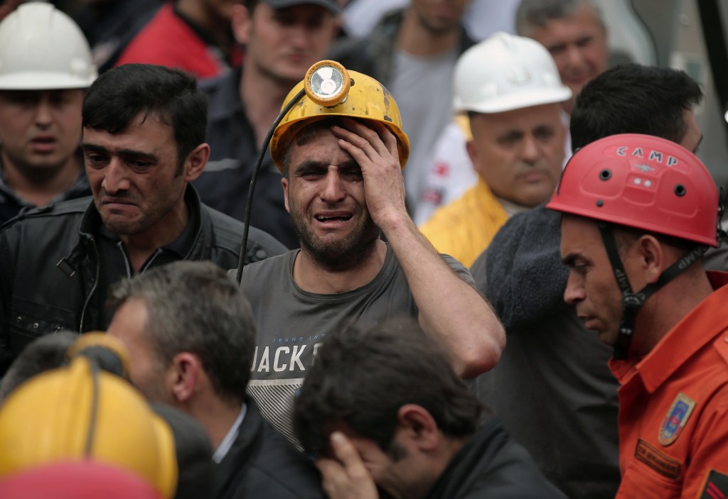 A miner cries as rescue workers carry the dead body of a miner from the mine in Soma, western Turkey, Wednesday, May 14, 2014. An explosion and fire at the coal mine killed at least 232 workers, authorities said, in one of the worst mining disasters in Turkish history. Turkey's Energy Minister Taner Yildiz said 787 people were inside the coal mine at the time of the accident. (AP Photo/Emrah Gurel)