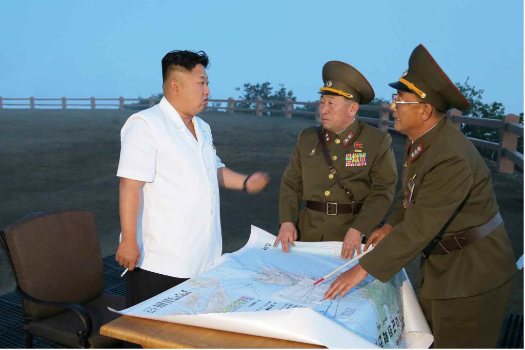 This Rodong Sinmun photo released on June 30, 2014, shows North Korean leader Kim Jong-un talking to military officials during a tactical rocket firing drill of the North's Strategic Force at an unidentified place.   (Yonhap)