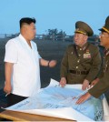 This Rodong Sinmun photo released on June 30, 2014, shows North Korean leader Kim Jong-un talking to military officials during a tactical rocket firing drill of the North's Strategic Force at an unidentified place.   (Yonhap)