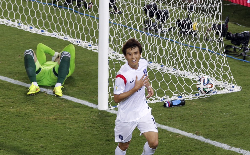 Russia's goalkeeper Igor Akinfeev, left, lies in the goal as South Korea's Koo Ja-cheol celebrates after scoring the opening goal during their group H World Cup soccer match at the Arena Pantanal in Cuiaba, Brazil, Tuesday, June 17, 2014. (AP Photo/Thanassis Stavrakis)