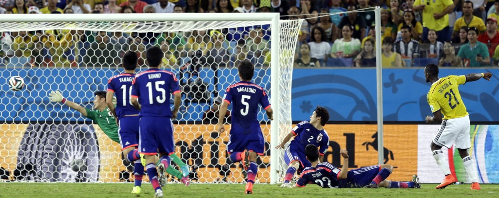 Colombia's Jackson Martinez, right, scores his side's third goal during the group C World Cup soccer match between Japan and Colombia at the Arena Pantanal in Cuiaba, Brazil, Tuesday, June 24, 2014. (AP Photo/Thanassis Stavrakis)