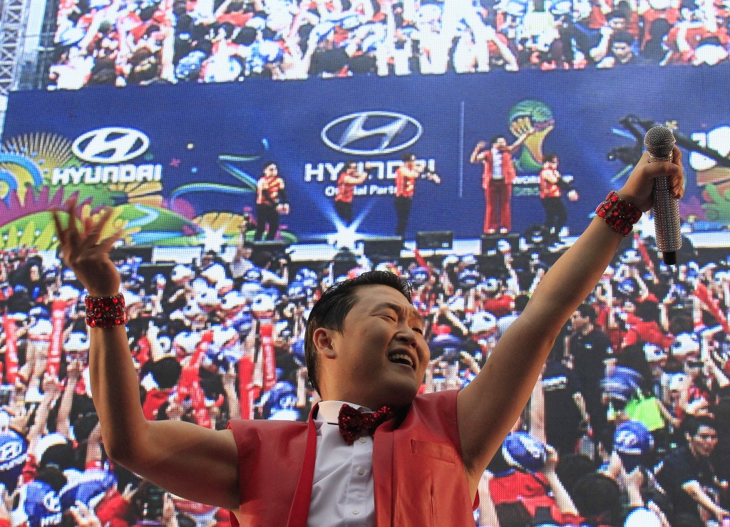 South Korean rapper PSY performs before a TV broadcasting 2014 Brazil World Cup Group H game between South Korea and Russia at a public viewing venue in Seoul, South Korea, Wednesday, June 18, 2014.(AP Photo/Ahn Young-joon)