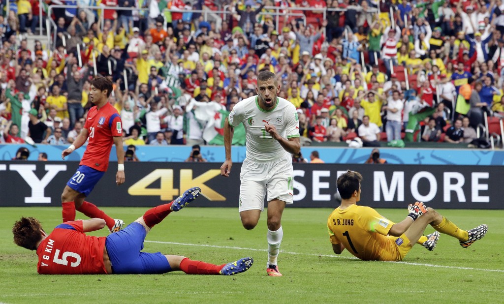 Algeria's Islam Slimani (13) runs past South Korea's goalkeeper Jung Sung-ryong, right, after scoring his side's first goal during the group H World Cup soccer match between South Korea and Algeria at the Estadio Beira-Rio in Porto Alegre, Brazil, Sunday, June 22, 2014. (AP Photo/Lee Jin-man)