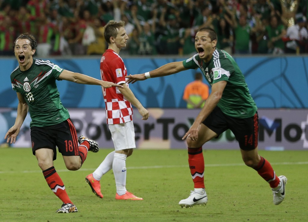 Mexico's Andres Guardado, center, celebrates with Mexico's Javier Hernandez, right, after he scored his team's second goal during the group A World Cup soccer match between Croatia and Mexico at the Arena Pernambuco in Recife, Brazil, Monday, June 23, 2014. Mexico won 3-1.(AP Photo/Ricardo Mazalan)