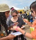 A Nabi USA member collects signatures from passerby at Santa Monica Pier for the 100 Million Signatures Campaign on June 21. (Kim Young-jae / The Korea Times)