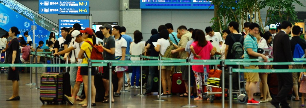 Travelers in line at a Korean airport.