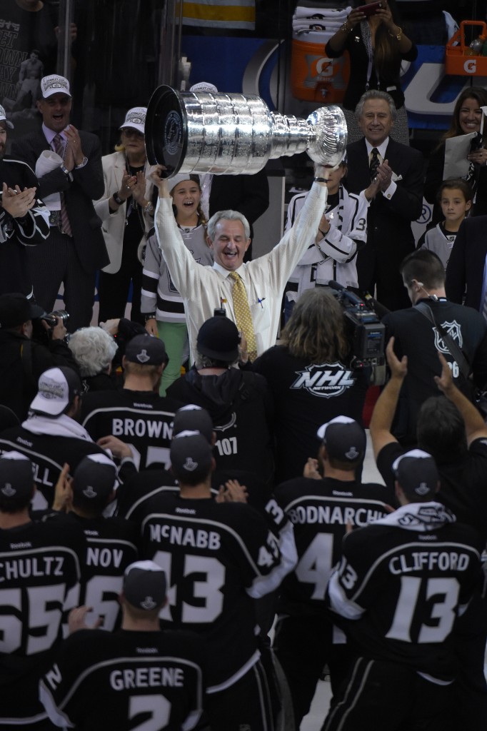 Los Angeles Kings head coach Darryl Sutter raises the Stanley Cup after the Kings beat the New York Rangers in Game 5 of the NHL Stanley Cup Final series Friday, June 13, 2014, in Los Angeles. The Kings won, 3-2. (AP Photo/Mark J. Terrill)
