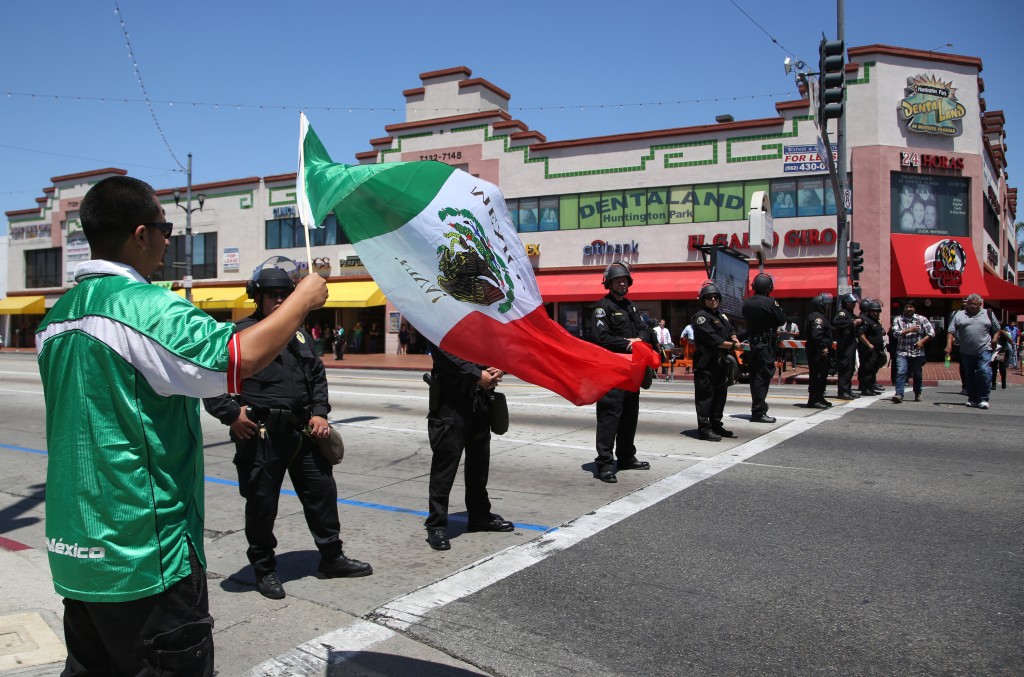Police officers block a street as Mexican soccer fans rally after the telecast of the 2014 World Cup Brazil between Brazil vs Mexico in Huntington Park, Calif., on Tuesday, June 17, 2014. Brazil failed to beat Mexico for the first time at a World Cup, held to a 0-0 draw in Fortaleza Tuesday in their second game in Group A. (AP Photo/Nick Ut)