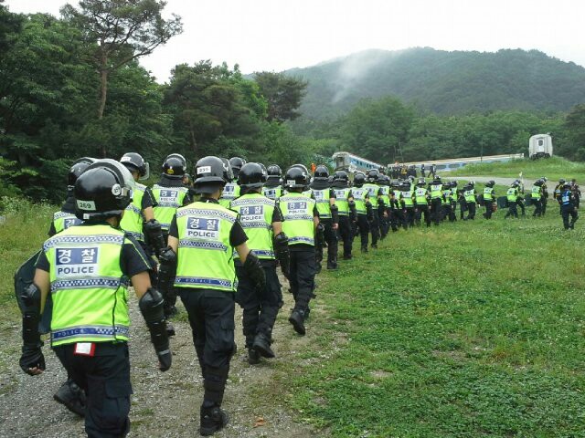 Police officers enter Geumsuwon, a stronghold of the Salvation Sect in Anseong, Gyeonggi Province, Wednesday. They searched the compound and detained supporters of Yoo Byung-eun, the sect's leader and de factor owner of the sunken ferry Sewol. (Yonhap)
