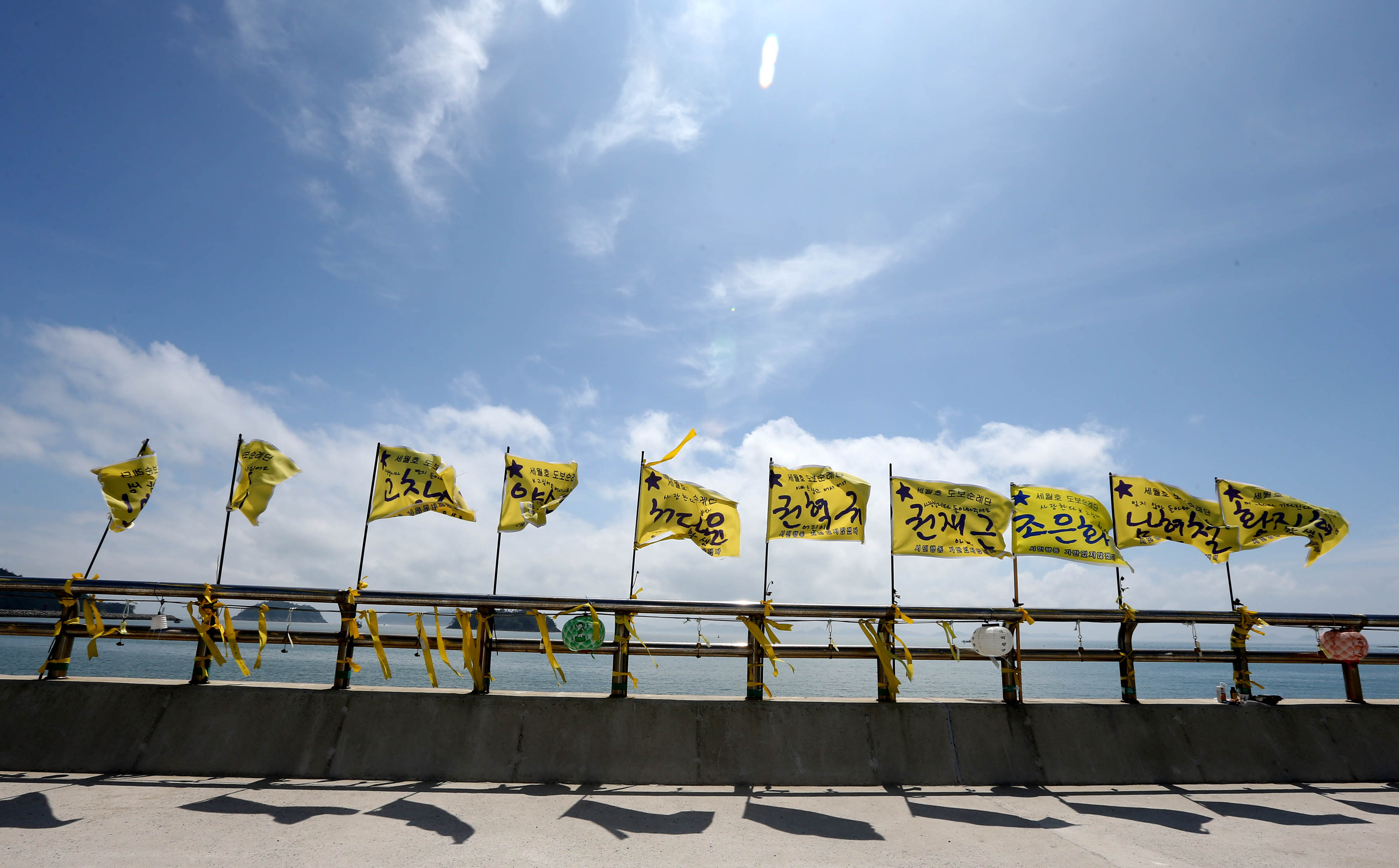Flags written with the names of 10 victims of the Sewol sinking wave in the wind in Jindo. (Hyung Min-woo/Yonhap)