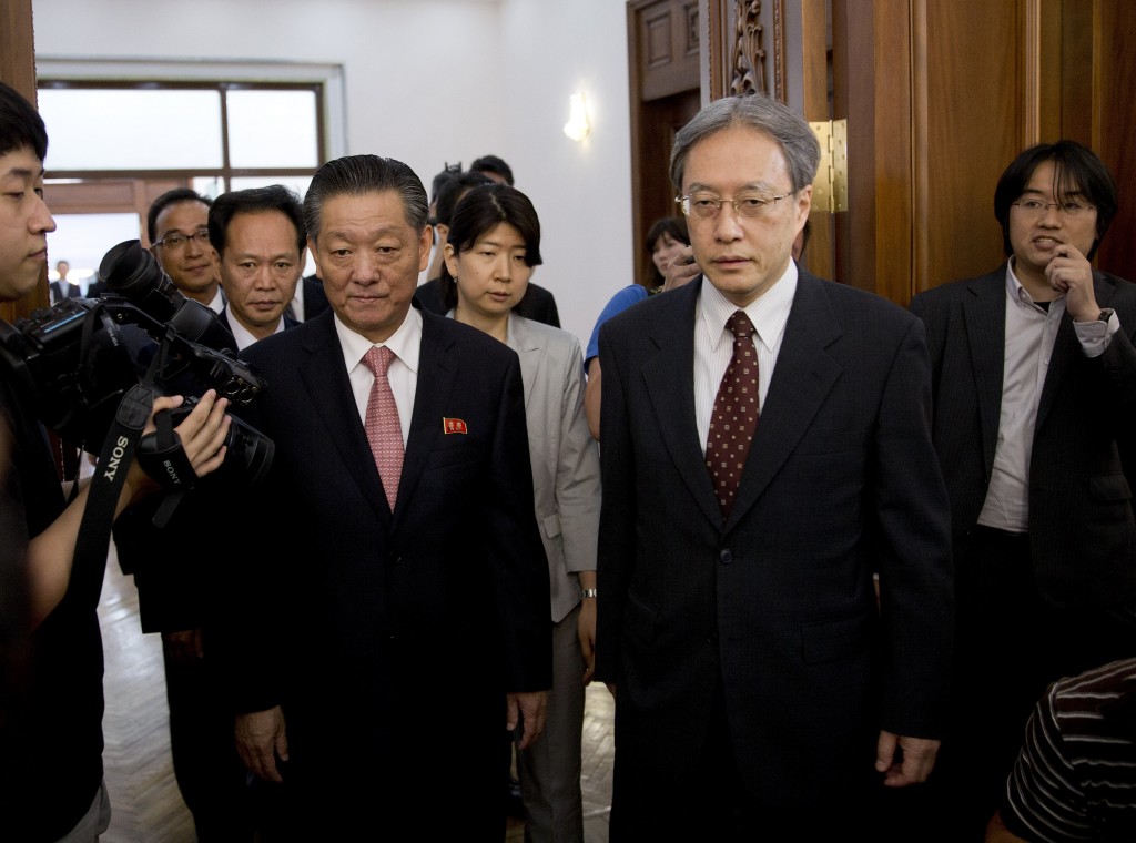 Song Il Ho, North Korea's ambassador in charge of normalizing relations with Japan, center left, and Junichi Ihara, head of the Japanese Foreign Ministry's Asian and Oceanian Affairs Bureau, center right, arrive for a meeting at the North Korean Embassy in Beijing, China Tuesday, July 1, 2014. (AP Photo/Andy Wong)