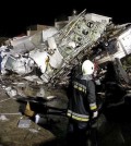 Rescue workers survey the wreckage of TransAsia Airways flight GE222 which crashed while attempting to land in stormy weather on the Taiwanese island of Penghu, late Wednesday, July 23, 2014. A transport minister said dozens of people were trapped and feared dead. (AP Photo/Wong Yao-wen)