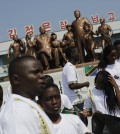 Students from the Laureat International School in Tanzania walk past a statue of the late North Korean leaders Kim Il Sung and Kim Jong Il, surrounded by children, on the parade square of the Songdowon International Children's Camp, Tuesday, July 29, 2014, in Wonsan, North Korea. Tightening the screws even further on travel to their already isolated country, North Korean authorities have barred foreigners from one of the year's most popular tourist events — the annual Pyongyang marathon — because of ongoing concerns over the spread of the Ebola virus, travel agencies said Monday, Feb. 23, 2015.(AP Photo/Wong Maye-E, File)