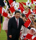 Chinese President Xi Jinping (C) and South Korean president Park Geun-hye (L) greets children waving the two national flags during a welcoming ceremony at the presidential Blue House in Seoul July 3, 2014.  (AP Photo/Kim Hong-ji, Pool)