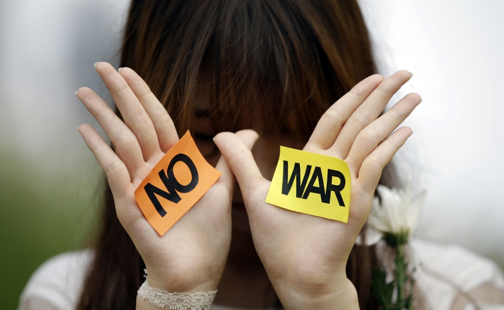 A South Korean students shows her palms with signs during a rally against the Israeli military operations in Gaza and the West Bank and wish for peace near the Israel Embassy in Seoul, South Korea, Wednesday, July 30, 2014. (AP Photo/Lee Jin-man)