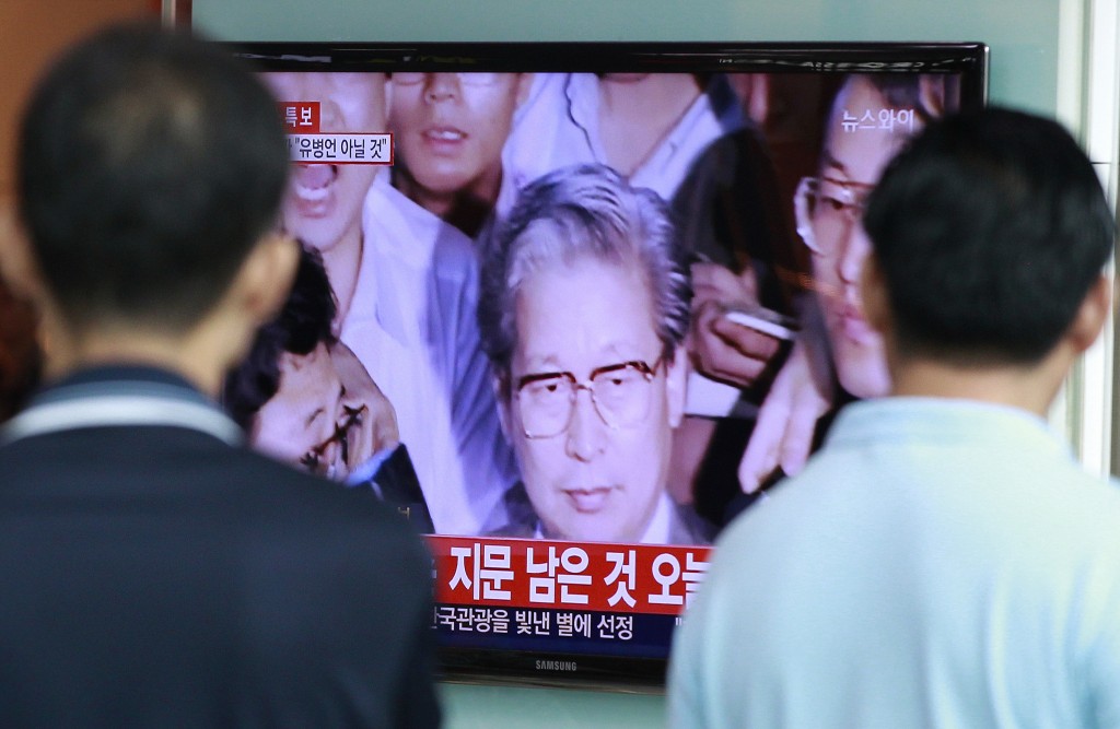 People watch a TV news program showing Yoo Byung-eun, the fugitive owner of the sunken ferry Sewol , at the Seoul Railway Station in Seoul, South Korea, Tuesday, July 22, 2014. South Korean police said Tuesday that a badly decomposed body of Yoo found surrounded by liquor bottles in a field last month was that of a fugitive billionaire businessman blamed for April's ferry disaster that killed more than 300 people.(AP Photo/Ahn Young-joon)