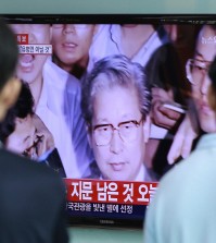 People watch a TV news program showing Yoo Byung-eun, the fugitive owner of the sunken ferry Sewol , at the Seoul Railway Station in Seoul, South Korea, Tuesday, July 22, 2014. South Korean police said Tuesday that a badly decomposed body of Yoo found surrounded by liquor bottles in a field last month was that of a fugitive billionaire businessman blamed for April's ferry disaster that killed more than 300 people.(AP Photo/Ahn Young-joon)