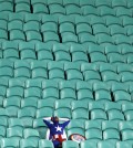 A lone U.S. supporter dressed as 'Captain America' sits in the stands after Belgium defeated the U.S. 2-1 in extra time to advance to the quarterfinals during the World Cup round of 16 soccer at the Arena Fonte Nova in Salvador, Brazil, Tuesday, July 1, 2014. (AP Photo/Natacha Pisarenko, File)