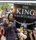 Fans whoop it up behind an ESPN reporter outside Quicken Loans Arena in Cleveland, after NBA basketball star LeBron James announced he would return to the Cleveland Cavaliers Friday, July 11, 2014. (AP Photo/Mark Duncan)