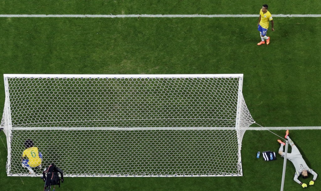 Brazil goalkeeper Julio Cesar, bottom right, lies on the pitch as Brazil's Marcelo, left, picks up the ball from the net after Germany's Andre Schuerrle scored, during the World Cup semifinal soccer match between Brazil and Germany at the Mineirao Stadium in Belo Horizonte, Brazil, Tuesday, July 8, 2014. Germany has routed host Brazil 7-1 and advanced to the final of the World Cup. Top right is Brazil's Luiz Gustavo. (AP Photo/Felipe Dana)