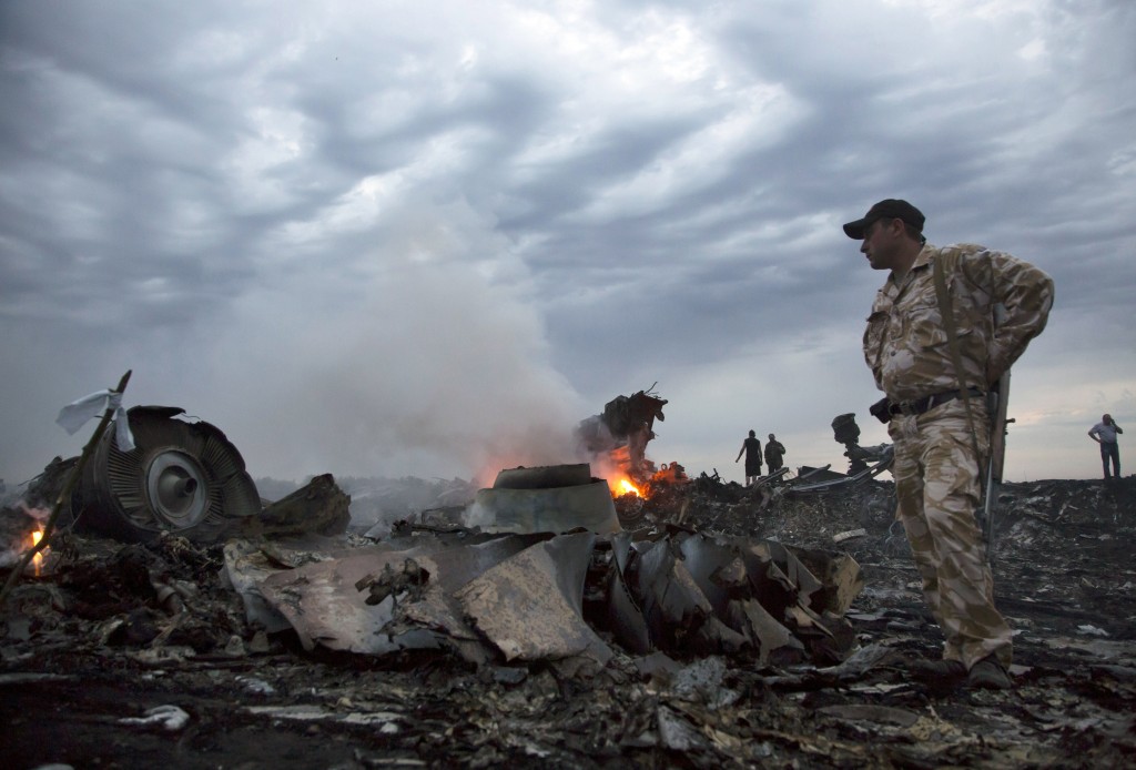 People walk amongst the debris, at the crash site of a passenger plane near the village of Grabovo, Ukraine, Thursday, July 17, 2014.  A Ukrainian official said a passenger plane carrying 295 people was shot down Thursday as it flew over the country and plumes of black smoke rose up near a rebel-held village in eastern Ukraine. Malaysia Airlines tweeted that it lost contact with one of its flights as it was traveling from Amsterdam to Kuala Lumpur over Ukrainian airspace.  (AP/Dmitry Lovetsky)