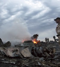 People walk amongst the debris, at the crash site of a passenger plane near the village of Grabovo, Ukraine, Thursday, July 17, 2014.  A Ukrainian official said a passenger plane carrying 295 people was shot down Thursday as it flew over the country and plumes of black smoke rose up near a rebel-held village in eastern Ukraine. Malaysia Airlines tweeted that it lost contact with one of its flights as it was traveling from Amsterdam to Kuala Lumpur over Ukrainian airspace.  (AP/Dmitry Lovetsky)