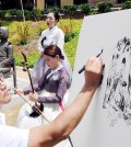 Artist Kim Jung-ki illustrates comfort women while two members of the Sooncheon performing arts company perform "Bong Seon-hwa" and "Arirang." (Park Sang-hyuk/The Korea Times)