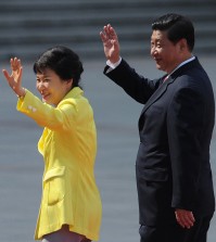 South Korean President Park Geun-hye, left, and Chinese President Xi Jinping wave during a welcoming ceremony outside the Great Hall of the People in Beijing Thursday, June 27, 2013.  (AP Photo/Wang Zhao, Pool)