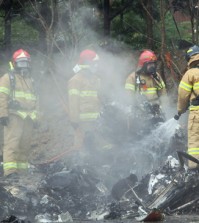 Firefighters work at the site of a helicopter crash that killed all five firefighters onboard in a residential area of Gwangju, Thursday. (Yonhap)