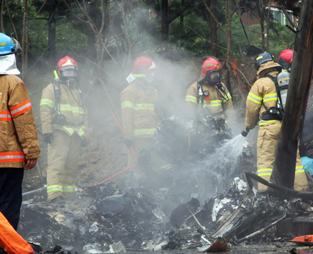 Firefighters work at the site of a helicopter crash that killed all five firefighters onboard in a residential area of Gwangju, Thursday. (Yonhap)