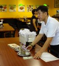 A waiter picks up a tip left at a table in a Koreatown restaurant.