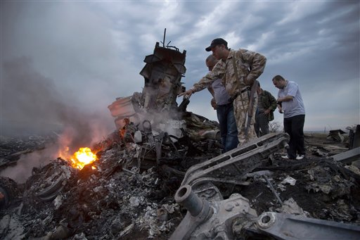 People inspect the crash site of a passenger plane near the village of Grabovo, Ukraine, Thursday, July 17, 2014. Koreans experienced similar attack some three decades ago, when Soviet forces shot down Korean Air Lines Flight 007. (AP Photo/Dmitry Lovetsky)