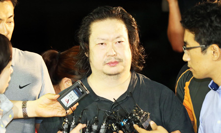 Yoo Dae-gyun, center, the eldest son of Yoo Byung-eun, the deceased owner of the sunken ferry Sewol, is surrounded by reporters after arriving at Incheon Metropolitan Police Agency, Friday. He was arrested by police in Yongin, Gyeonggi Province. (Yonhap)