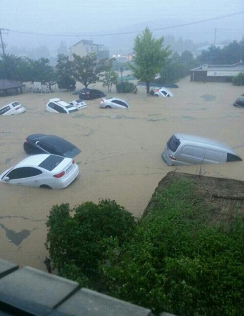 Cars are afloat in a flooded area in Geumjeong, Busan, Monday. Heavy rain hit the southern part of the country, causing flash floods, landslides, and suspension of subway service in some areas. (Yonhap)