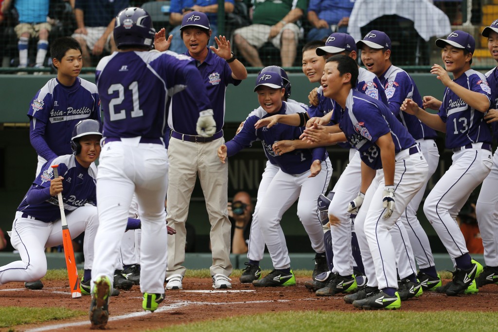 Seoul's Hae Chan Choi (21) is greeted by teammates after hitting a two-run home run off Tokyo pitcher Takuma Takahashi in the second inning of a International semi-final baseball game against Tokyo at the Little League World Series tournament in South Williamsport, Pa., Wednesday, Aug. 21, 2013. (AP Photo/Gene J. Puskar)