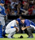 A member of the Los Angeles Dodgers training staff talks to injured starting pitcher Hyun-Jin Ryu (99) as catcher A.J. Ellis looks on at left, in the sixth inning of a baseball game against the Atlanta Braves Wednesday, Aug. 13, 2014, in Atlanta. Ryu left the game under his own power. (AP Photo/John Bazemore)