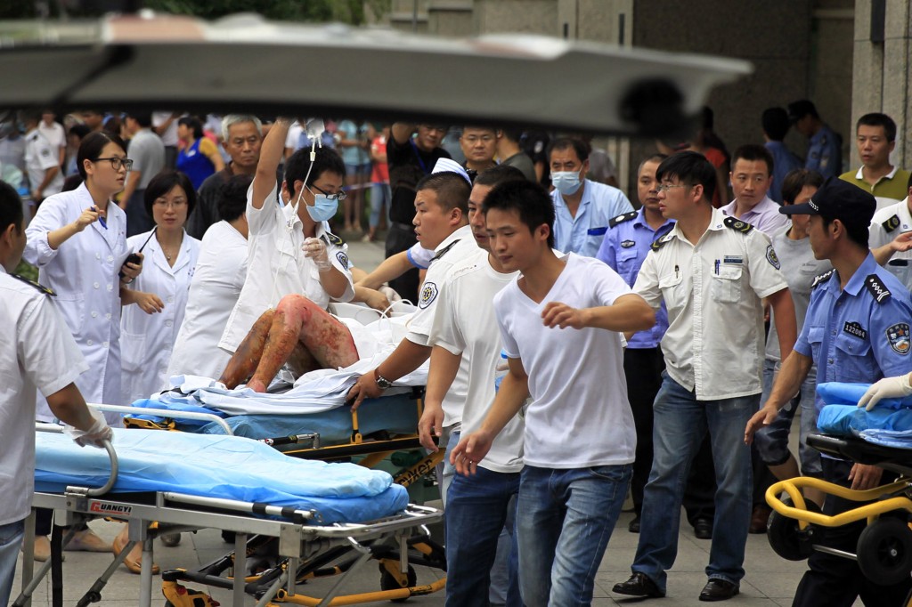 Medical staff move a severely burnt victim of an explosion at an eastern Chinese automotive parts factory from a hospital in the city of Kunshan, Jiangsu province, Saturday, Aug. 2, 2014 to a Shanghai hospital which is better equipped to handle severe burns. Dozens of people were killed Saturday by the explosion at the factory that supplies General Motors, state media reported. (AP Photo) 