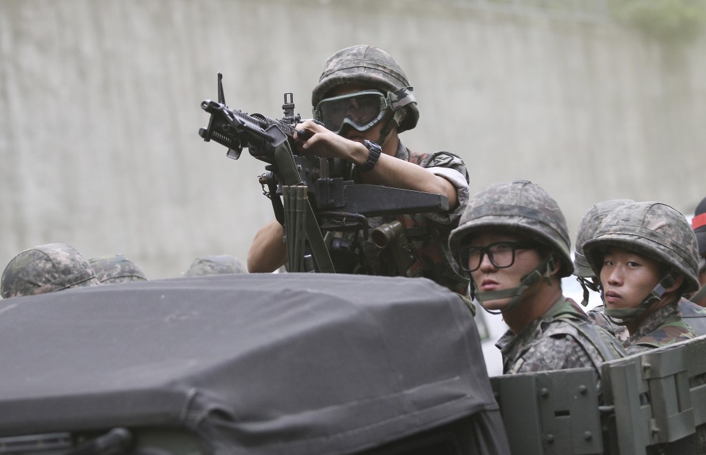 A South Korean aims his machine gun during an anti-terror exercise as part of Ulchi  Freedom Guardian in Seoul, South Korea, Monday, Aug. 18, 2014. The U.S.-South Korean military exercises start Monday and involving tens of thousands of troops are described by the allies as routine and defensive, but Pyongyang sees them as invasion preparation. (AP Photo/Ahn Young-joon)